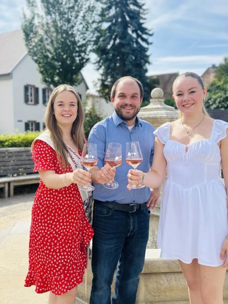 Tessa-Marie Müller (rechts) übernimmt das Amt des Fräuleins von Flörsheim von Marie-Sophie Döß (links). Ortsbürgermeister Tobias Rohrwick (Mitte) freut sich über die gelungene Nachfolge.